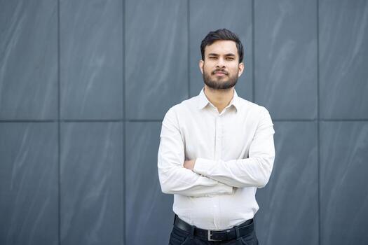 confident man standing against gray wall 2023 photo